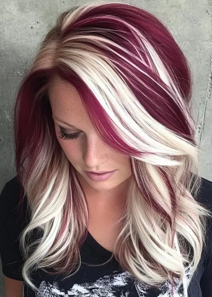 Wine red plus bold platinum-blonde front streaks on collarbone-length layered cut with volume at the crown