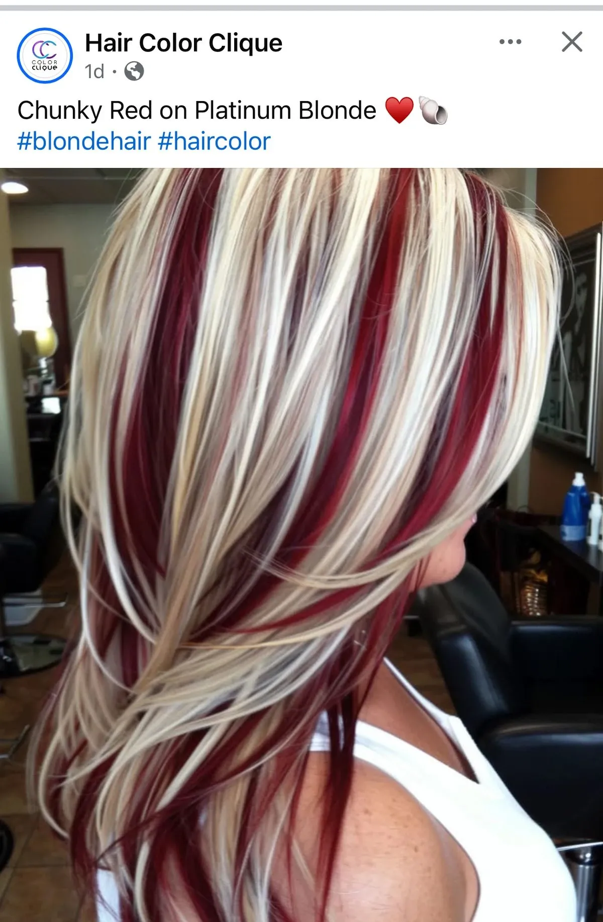 Platinum blonde base with cherry-red sliced sections on medium-length rounded layers with directional blowout styling