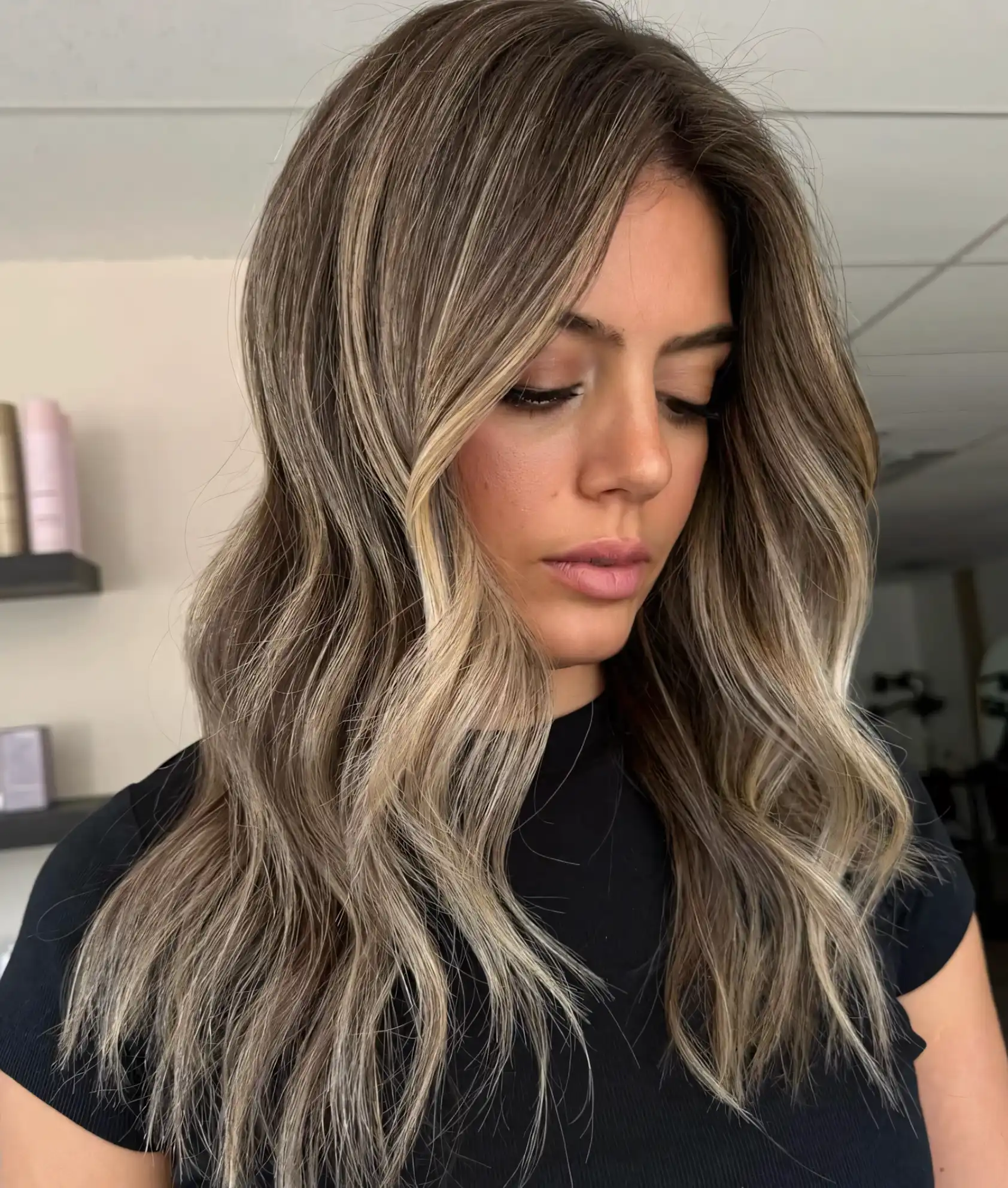 Long layered dark blonde hair with beige highlights and bright face framing