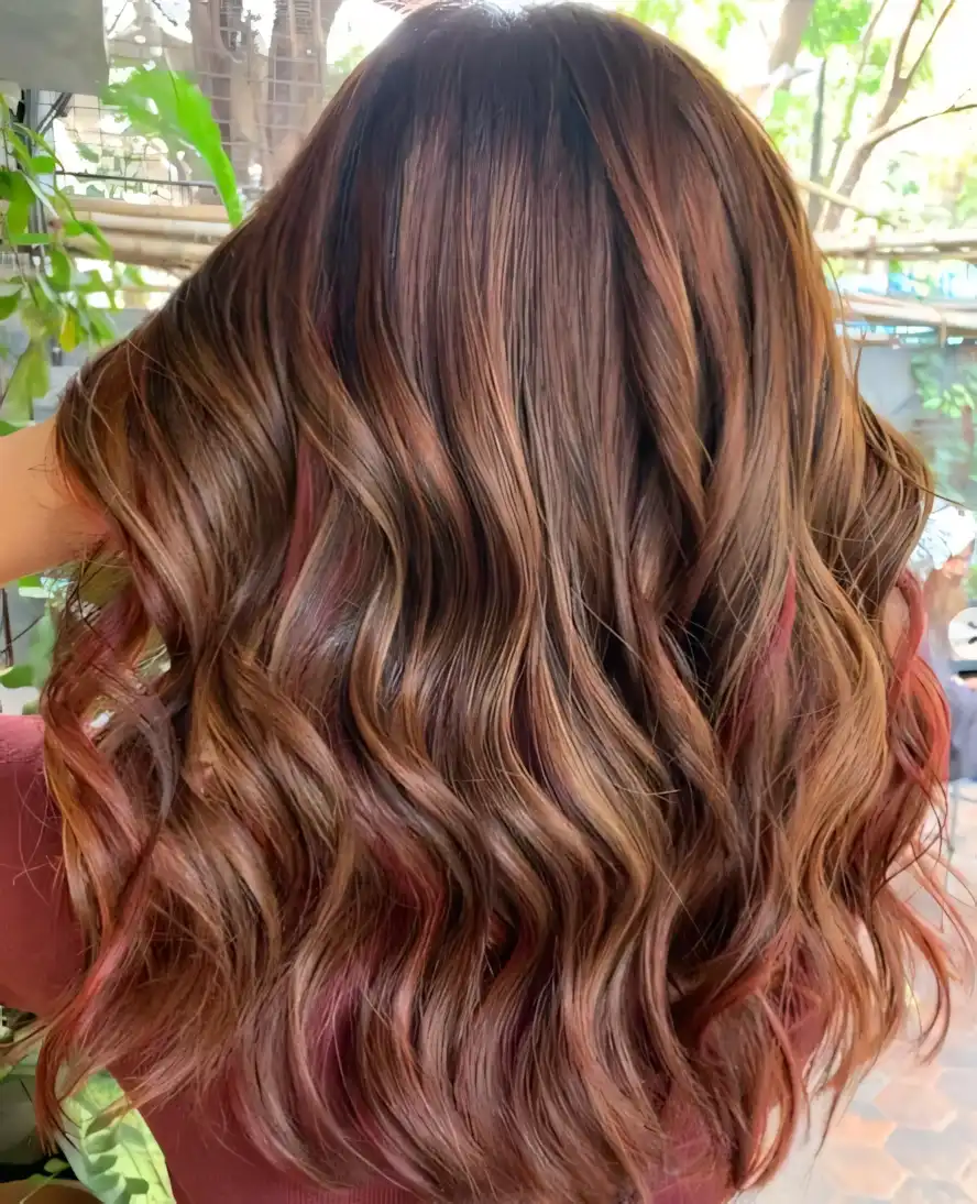 Chestnut brown long wavy hair with subtle copper red highlights