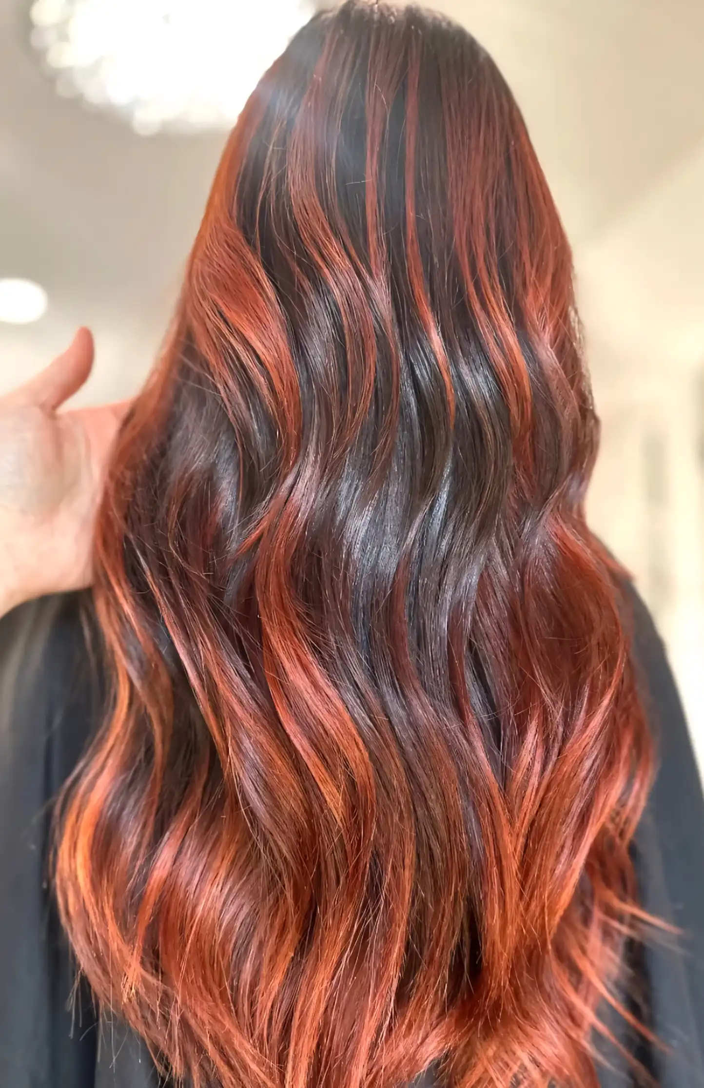 Long dark brown hair with glowing ginger copper highlights at the ends