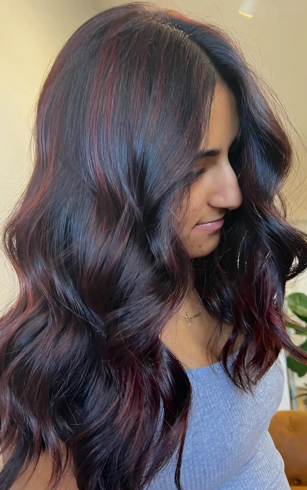 Dark nearly black wavy hair with subtle mahogany wine red highlights