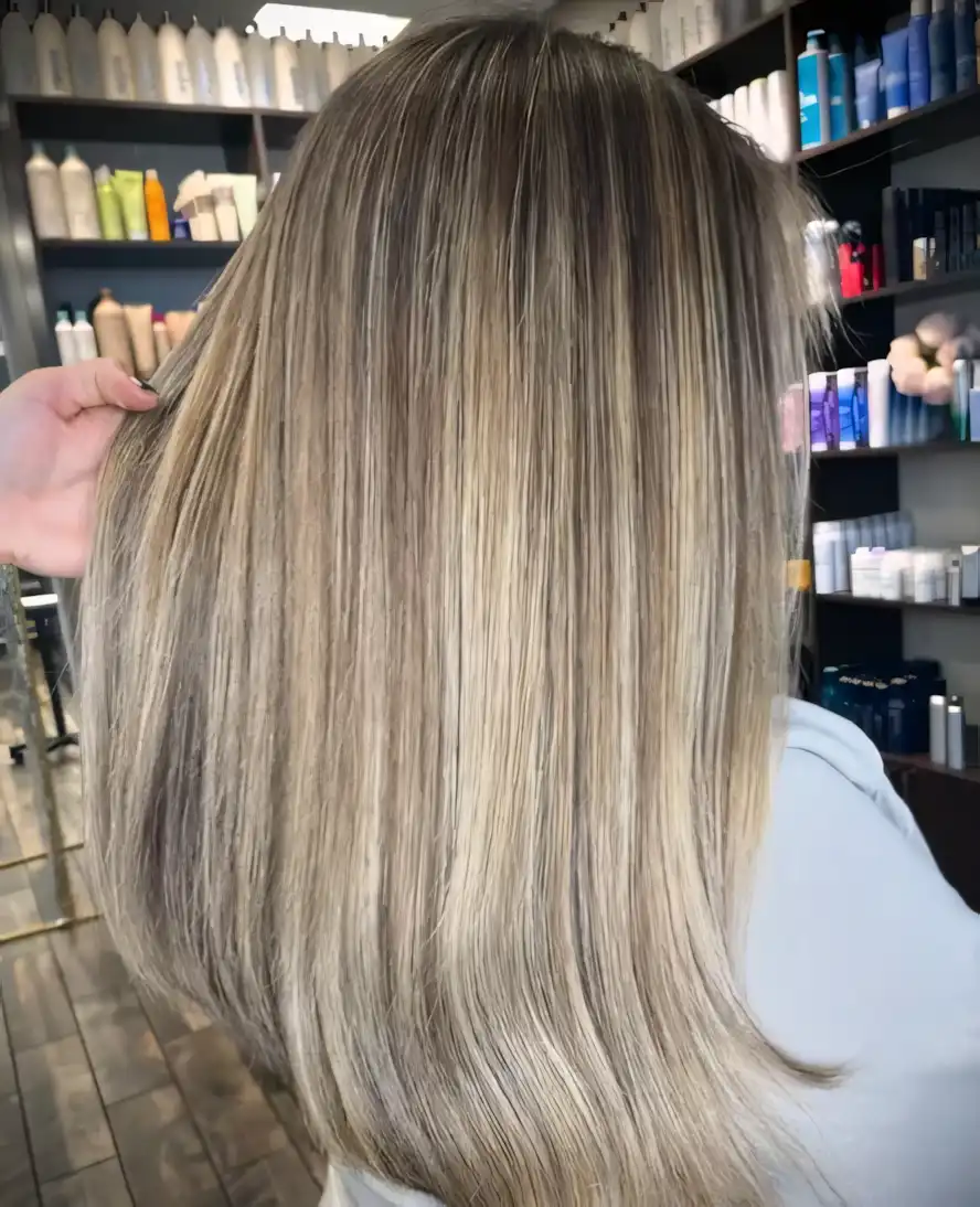 Sandy blonde straight hair with soft sun-kissed balayage highlights