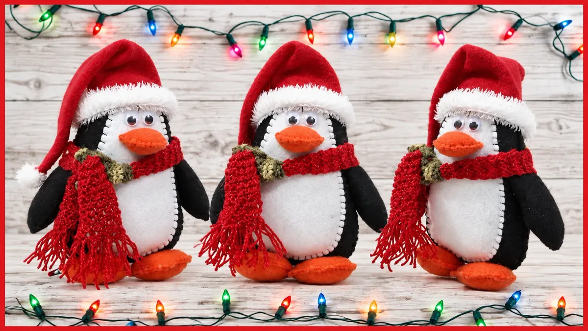 Handmade Christmas felt penguins wearing red Santa hats and scarves